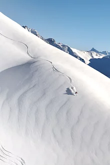 Freerider im Tiefschnee vom Gipfel zum Tal unterwegs